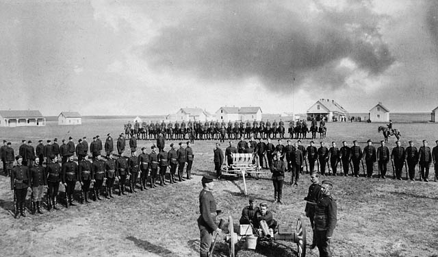 North-West Mounted Police barracks and parade square at Regina, 1885, with a seven-pounder gun